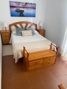 sypialnia z łóżkiem z drewnianą deską w obiekcie SUNSET Home ISLANTILLA w mieście Islantilla