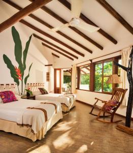 a room with three beds and a ceiling with windows at Villa Maya in Flores
