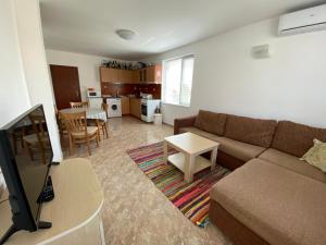 a living room with a couch and a table at Apartments in complex Daisy in Kranevo