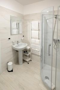 a white bathroom with a sink and a shower at Park Hotel Villa Salzea in Trofarello