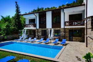 a villa with a swimming pool in front of a house at Relax Houses in Ognyanovo