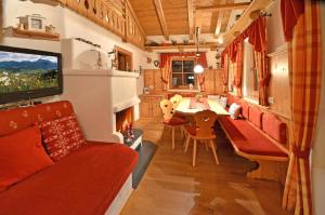 a living room with a couch and a dining room at Chalet Berghof in Flachau