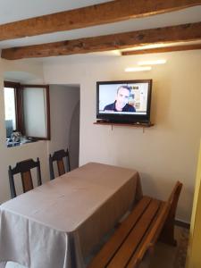 a room with a table and a tv on a wall at Apartman STELLA MARIS in Veli Lošinj