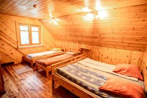 a room with two beds in a wooden cabin at Pas Kaziuką namas-sodyba in Ignalina
