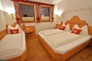 1 dormitorio con 2 camas y 2 ventanas en Chalet Berghof, en Flachau