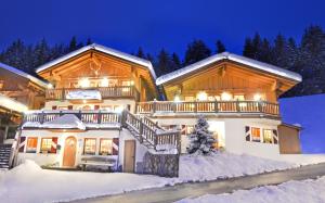 una casa nella neve di notte di Chalet Berghof a Flachau