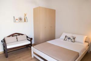 Un pequeño dormitorio con una cama y una silla. en CASA CUORE Quiet and authentic near the sea, en Káto Ássos