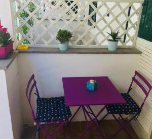 een paarse tafel en 2 stoelen op een balkon bij Casa Stella Marina in Anzio