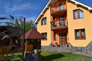 a yellow building with a gazebo in front of it at Casa Traditionala Breb in Breb