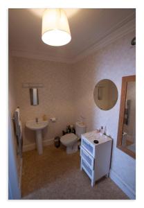 uma casa de banho com um WC, um lavatório e um espelho. em Cornmill House, With Outstanding Sea Views In Garlieston em Garlieston