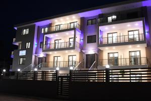 un edificio con luces moradas en él por la noche en Theano Luxury Suites Nikiti en Nikiti