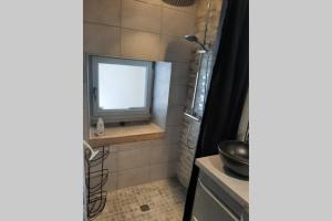baño con lavabo y ventana en Petit gîte rural - la Forge -, en Sainte-Marie-sur-Ouche