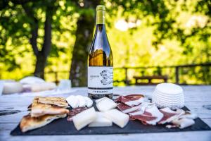 Agriturismo le due querce في Cerreto di Spoleto: زجاجة من النبيذ موضوعة على طاولة مع الطعام