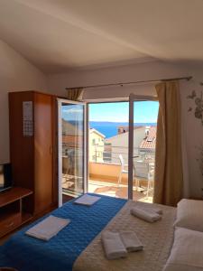 a bedroom with a bed and a view of a balcony at Apartmani Katarina in Makarska