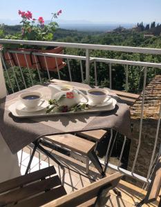 une table avec une assiette de nourriture sur un balcon dans l'établissement Fiori e farfalle apartment, à Caprarola