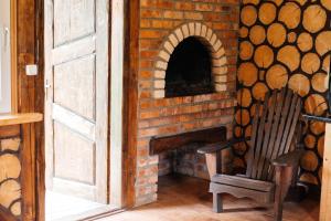 a brick oven with a wooden chair in a room at Котедж з неймовірними краєвидами in Slavske