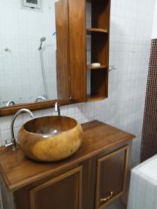 a bathroom sink with a large wooden bowl at Résidence Fadi Diamniadio in Dakar