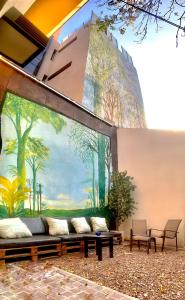 un edificio con sofá frente a un mural en Jaque Mate Hostel en Mendoza