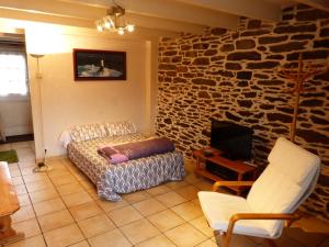 - un salon avec un canapé et un mur en pierre dans l'établissement GITE DE CARACTERE, à Lopérec