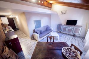 ein Wohnzimmer mit Sofa und Fernseher in der Unterkunft Maison Ville d'Aoste in Aosta + 3 Fotos