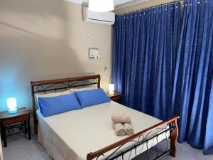 a bedroom with a bed with blue pillows on it at City Center Apartments in Mellieħa