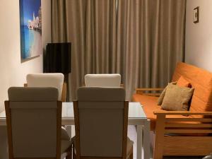 een kamer met een tafel en stoelen en een bank bij City Center Apartments in Mellieħa