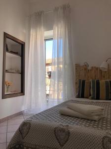 - une chambre avec un lit et une grande fenêtre dans l'établissement Fiori e farfalle apartment, à Caprarola