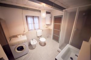 ein Badezimmer mit Toilette, Waschbecken und Waschmaschine in der Unterkunft Maison Ville d'Aoste in Aosta
