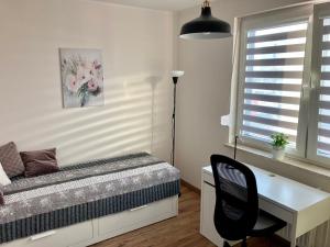 1 dormitorio con cama, escritorio y ventana en Apartament Łagiewniki en Cracovia