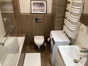 a bathroom with a toilet and a sink and a shower at Apartament Łagiewniki in Krakow