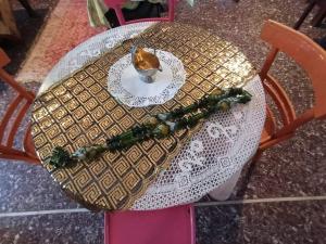 a table with a white table cloth and a plate with a flower arrangement at Anatoli Hotel in Agia Marina Aegina
