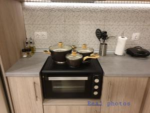 a kitchen with two pots on top of a microwave at blue - comfy center rodos in Asgourou