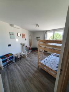 ein Schlafzimmer mit einem Etagenbett und einem großen Fenster in der Unterkunft Le petit provencal in Espeluche