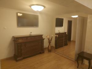 a room with a dresser and a vase with flowers in it at CASA LUCA in Moldova Nouă