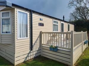 a house with a deck and a fence at Shorefield Country Park Self-Catering Holiday Home in Lymington