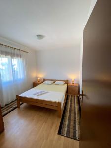 een slaapkamer met een bed met twee kaarsen erop bij Apartman Popović in Virpazar