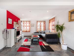 a living room with a couch and a red wall at Apartment only 100 m from Althausen Castle 