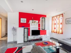 uma sala de estar com uma parede de acento vermelho em Apartment only 100 m from Althausen Castle 