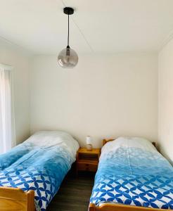 a bedroom with two beds and a lamp at Cosy house in the heart of the center! in Oostburg