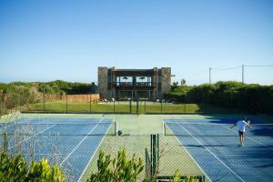 two people playing tennis on a tennis court at CASA HORTENSIAS in Quequén