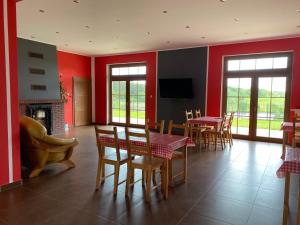 a living room with red walls and a table and chairs at AgroBorcz in Borcz