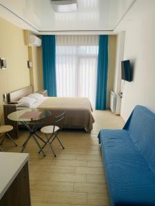 巴统Downtown Batumi apartment的一间配有床、桌子和沙发的酒店房间