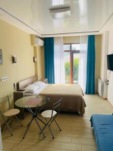 巴统Downtown Batumi apartment的一间带床、桌椅的酒店房间