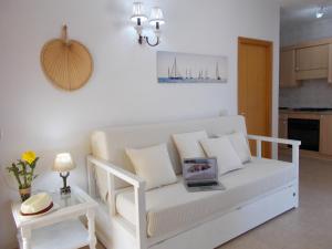 um sofá branco numa sala de estar com uma mesa em Casa Marcos em Playa Migjorn