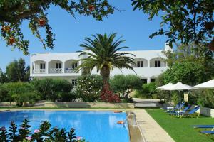 a large white building with a swimming pool in front of a house at Mantenia Hotel in Platanes