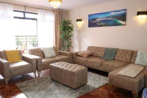 sala de estar con sofá y silla en Glamour Suites, en Nanyuki