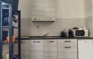 a kitchen with a sink and a microwave at Casa L'abbraccio in Livorno