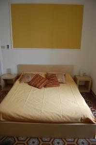 a large bed in a room with two tables at Arena Alfieri B&B in Livorno