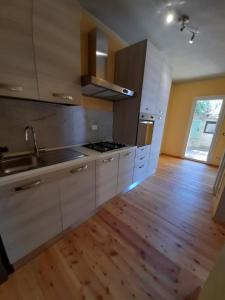 a kitchen with white cabinets and a wooden floor at Atena in La Spezia +49 photos