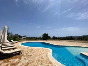 uma piscina com espreguiçadeiras e cadeiras ao lado de um resort em CAN FARITZEO em Sant Rafael de Sa Creu